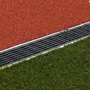 ACO Sport Precast Trench Drainage Systems installed between a track surface and synthetic turf playing field