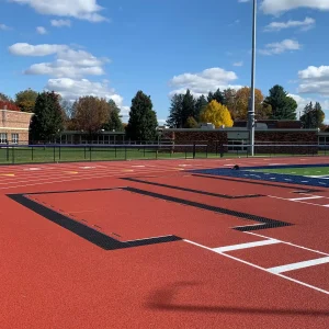 a long / triple jump pit with aluminum sand pit covers installed to keep the pit debris free