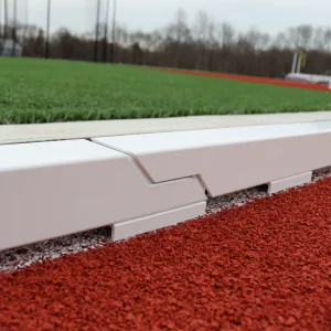 an aluminum track curb installed around a track running surface