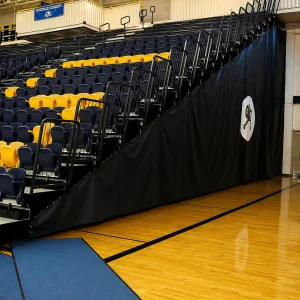 a set of high school bleachers with bleacher enclosures down the side. the schools logo is printed on the side.