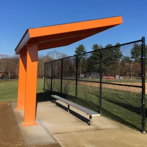 an orange cantilever dugout installed down the left foul line of a baseball field