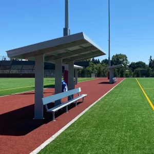 A row of Cantilever Dugouts with semi-permanent team benches installed on the side of a turf soccer field