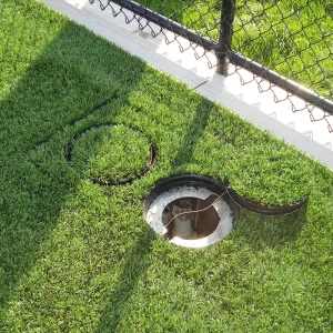 Dual ComBox® Electrical / Communications Box installed in a synthetic turf field with one cover open