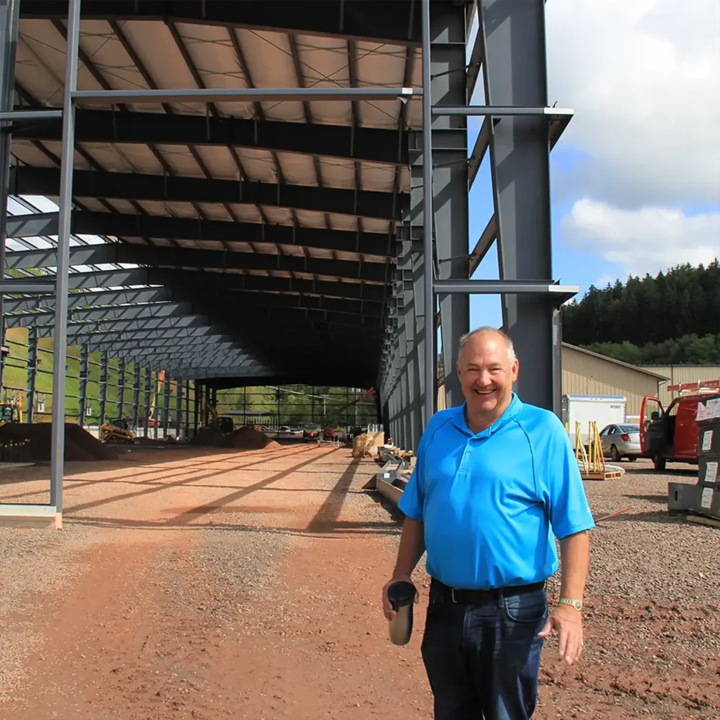Mr. Clark standing in front of the newly constructed manufacturing expansion at the Sportsfield Specialties headquarters