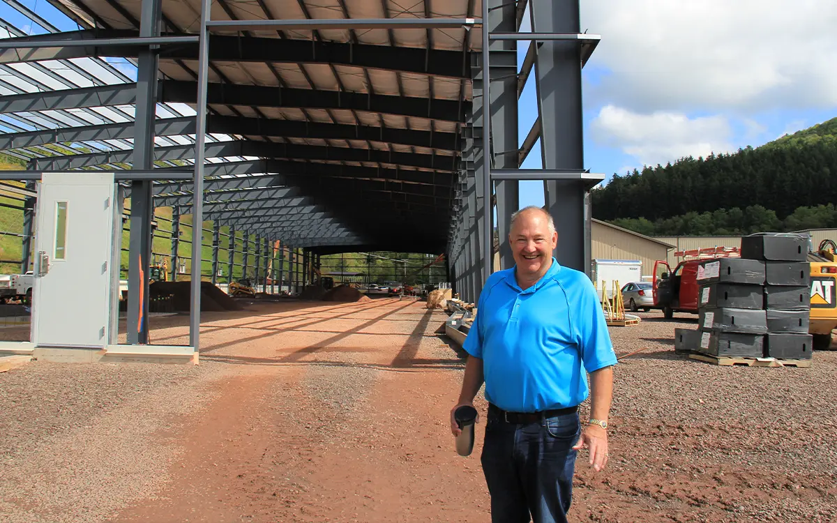 Scott Clark of Clark Companies standing in front of framework of new manufacturing facility at Sportsfield Specialties