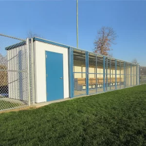 An white and blue enclosed dugout by sportsfield specialties installed with a storage closet and polyboard team benches on a natural grass playing field