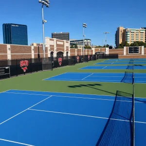a blue and green tennis court with external wind tennis net systems installed