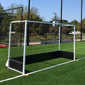 a field hockey goal with black baseboards sitting on a synthetic turf playing field