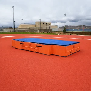 a blue and orange DuraZone® high jump landing system sitting on a track & field surface