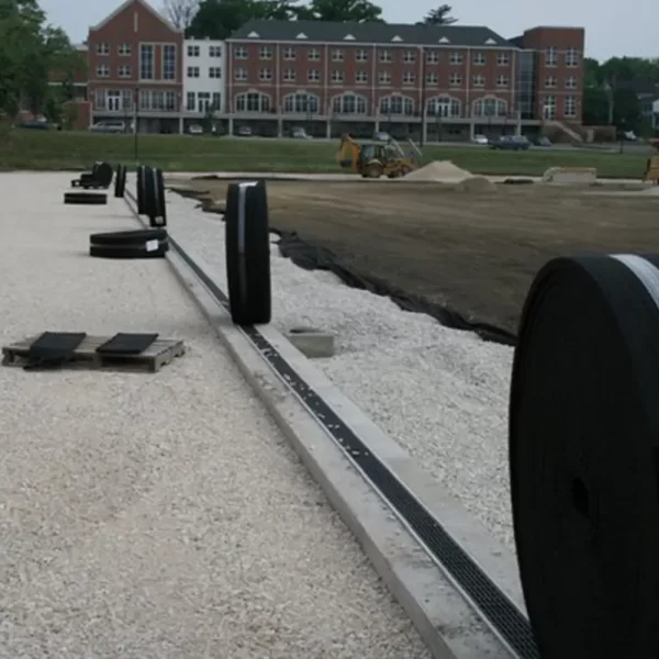 Hydraway™ Subsurface Drainage being unrolled alongside a playing field in construction