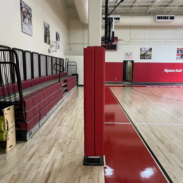 a column wrapped in red indoor column padding inside a gymnasium