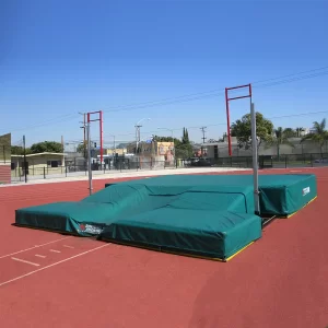 JumpZone® Pole Vault Landing Pad on the track with a green protective cover when not in use