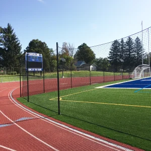 a lacrosse netting system installed between a track surface and a multi-purpose athletic field at Haverling