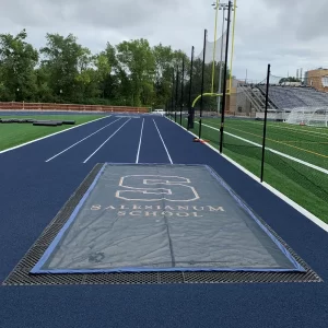 A Weighted Mesh cover protecting a sand pit from debris - the cover has a digitally printed school logo on it