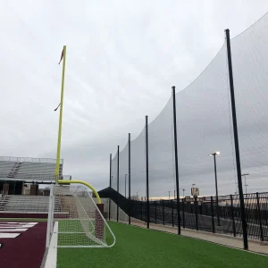 a StormGuard® multi-sport netting system installed behind a Goalpak® combination goal and in front of a busy parking lot