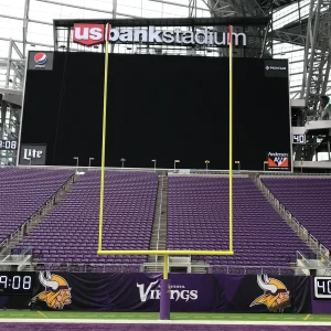 a plate mount football goal post in the upright position with goal post padding installed in the end zone of the Minnesota Vikings stadium
