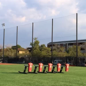 A pole-to-pole tension netting system installed between a multi-use playing field and a residential houses