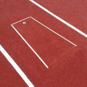 a pole vault planting box installed in a track surface with the cover plug in place