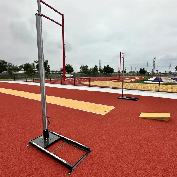 Pole vault standards sitting on the track surface waiting for the pole vault padding to be installed