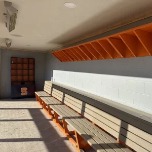 tan and orange polyboard team bench installed at the Syracuse Softball enclosed dugout