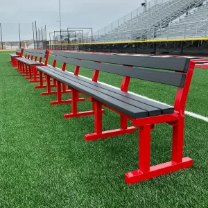 A row of red polyboard team benches on the side of a soccer field