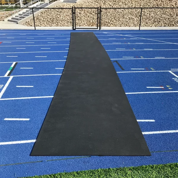 a black Roll-Out Track Protector laid across the track surface ready for pedestrians and athletes to walk across without damaging the surface