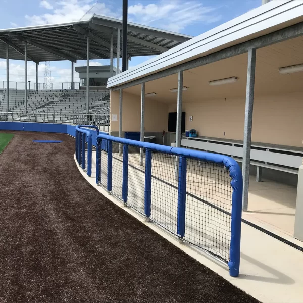 blue round guard rail padding installed in front of dugout at baseball field