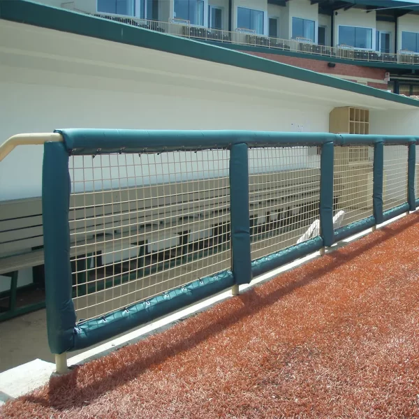 looking through round guard rail padding into the baseball dugout