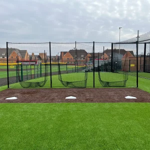 a 3 station soft toss netting system installed in the practice area of a multi-purpose playing field