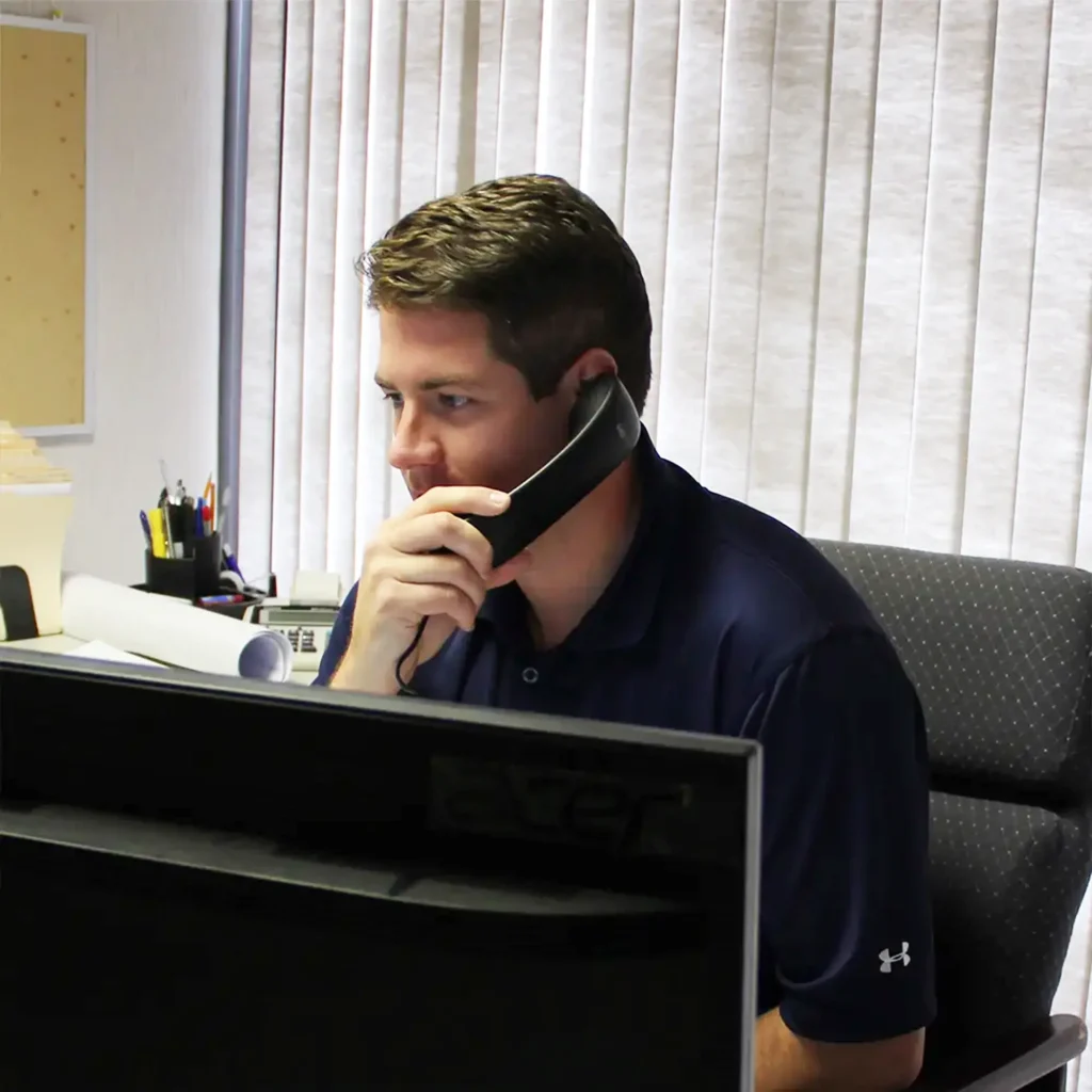 Matt Moyse, Regional Sales Manager, sitting at his desk talking to a customer
