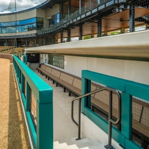 green squared guard rail padding installed in a below ground enclosed dugout