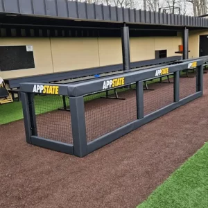 black squared guard rail padding installed in front of a softball dugout - customized with digitally printed graphics
