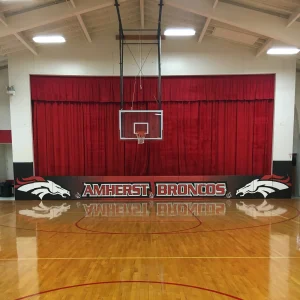 stage mats with digitally printed graphics installed on the side of a shared gymnasium space