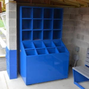 A blue Stand Up Bat & Helmet Storage Unit installed in an enclosed dugout