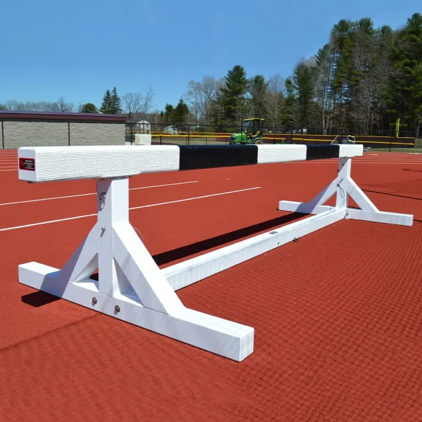 Portable Adjustable Steeplechase Hurdle set to the side of a track running surface