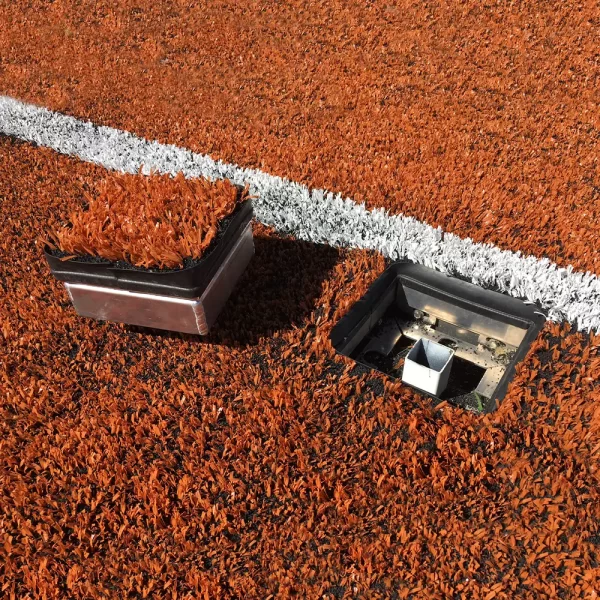 An open access frame kit installed on a orange turf ball field