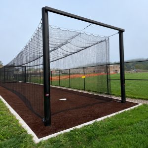 a tension batting tunnel installed in the practice area of a college baseball field