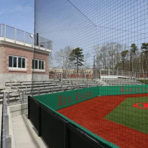 tension netting with integrated wall pad backstops installed at a college baseball field