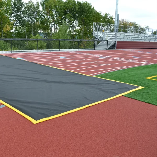 black with yellow trim Track Crossing Mat laid across the track allowing athletes and pedestrians to walk across without damaging the surface