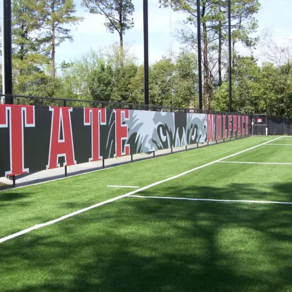 Custom windscreen with digitally printed graphics installed alongside the chain link fence of a tennis court