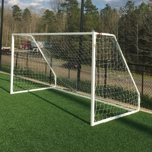 a youth soccer goal sitting on the sidelines of a synthetic turf playing field